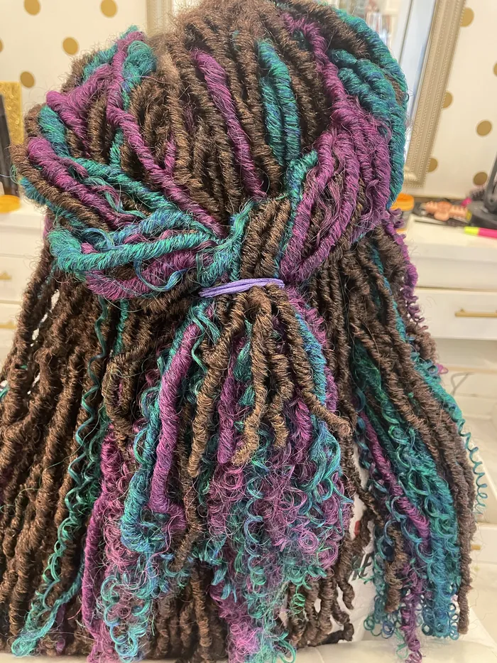 Long locs wrapped with purple and teal colour through the length